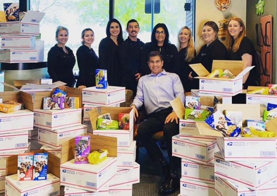 Dr. Christopher Rose and staff prepare Girl Scout gift packages (530 boxes of Girl Scout cookies) for military members on deployment.